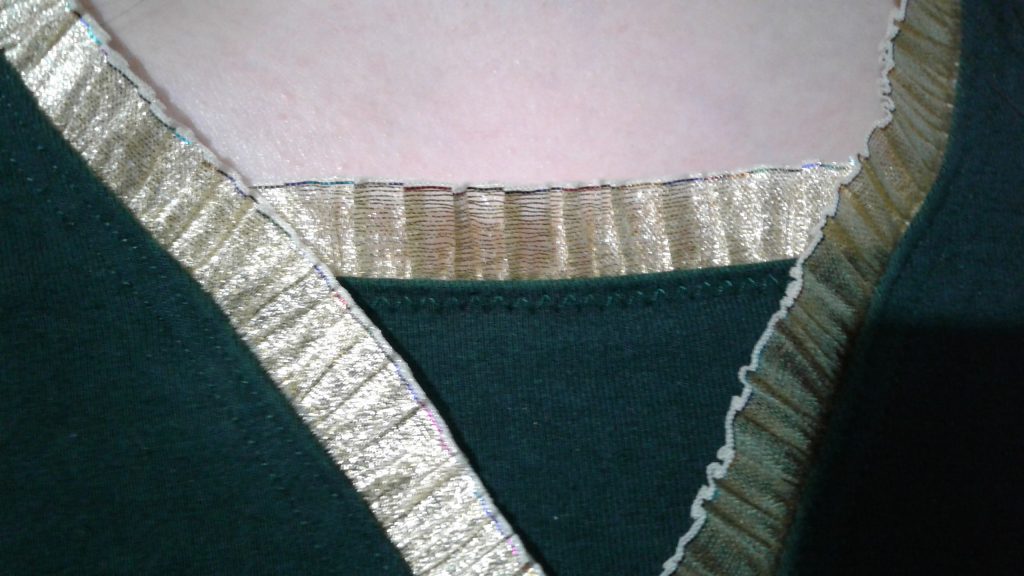 closeup of gold trim on neckline of green wrap blouse